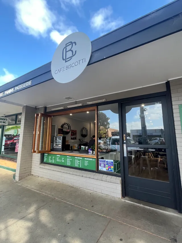 Cafe Biscotti storefront on sunny day with CB logo, open service window and menu board visible